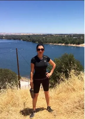 a woman standing on a hill near a body of water at The village Inn in Fair Oaks