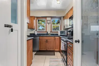 a kitchen with wooden cabinets and a stove top oven at The village Inn in Fair Oaks
