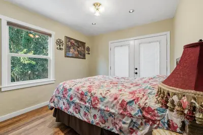 a bedroom with a bed and two windows at The village Inn in Fair Oaks