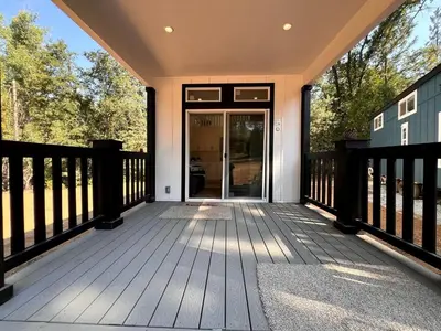 a large wooden deck with a glass door at Bright Modern Tiny Retreat with Yoga Dome Near Yosemite, Groveland, California in Groveland