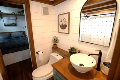 a bathroom with a sink and a toilet and a bed at Cozy Modern Tiny Retreat with Yoga Dome, Garden, and Stargazing in Groveland, California in Groveland