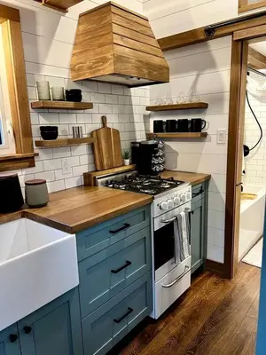a kitchen with blue cabinets and a stove top oven at Cozy Modern Tiny Retreat with Yoga Dome, Garden, and Stargazing in Groveland, California in Groveland