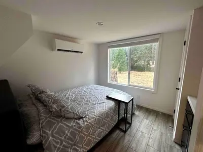 a bedroom with a bed and a large window at Charming Bright Tiny Home with Stargazing & Yoga Dome Near Yosemite, Groveland, California in Groveland