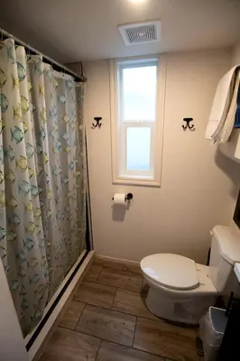 a bathroom with a toilet and a shower curtain at Charming Bright Tiny Home with Stargazing & Yoga Dome Near Yosemite, Groveland, California in Groveland