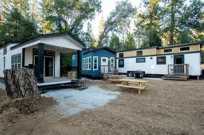 a couple of rvs parked next to each other at Charming Bright Tiny Home with Stargazing & Yoga Dome Near Yosemite, Groveland, California in Groveland