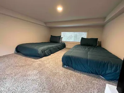 two beds in a small room with a window at Charming Bright Tiny Home with Stargazing & Yoga Dome Near Yosemite, Groveland, California in Groveland