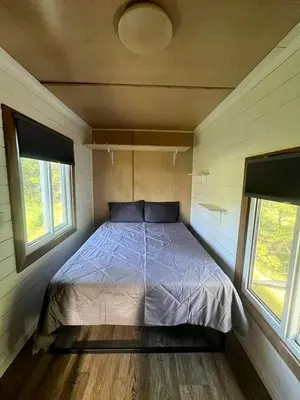 a bed in a small room with two windows at Cozy Modern Tiny Retreat with Stargazing & Yoga Dome Access Near Yosemite Tioga Pass, Groveland, California in Groveland
