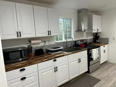 a kitchen with white cabinets and a sink and a microwave at Cozy Nature-Filled Home with Garden & Night Sky Views Near Yosemite Tioga Pass, Groveland CA in Groveland