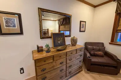 a room with a dresser with a mirror and a chair at Lazy Bear Manor in South Lake Tahoe