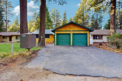 a garage with a green garage door in front of a house at Whispering Pines Retreat in South Lake Tahoe