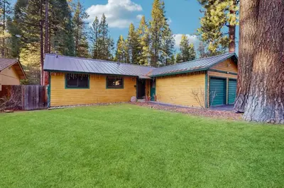 a yellow house with a yard in front of it at Whispering Pines Retreat in South Lake Tahoe