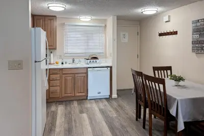 a kitchen with a table and a white refrigerator at Lakeview Gem in South Lake Tahoe