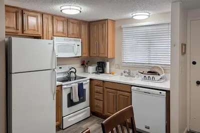 a kitchen with wooden cabinets and a white refrigerator at Lakeview Gem in South Lake Tahoe