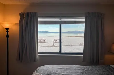 a bedroom with a window with a view of the beach at Lakeview Gem in South Lake Tahoe