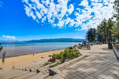 a beach with people sitting on a bench at Lakeview Gem in South Lake Tahoe