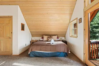 a bed in a room with a wooden ceiling at Mountain Paradise- Family Cabin w Pool Table in Shaver Lake