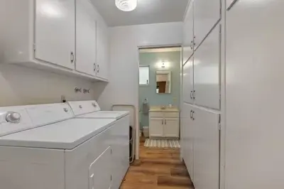a white kitchen with white cabinets and a refrigerator at Mountain View House in Mi-Wuk Village