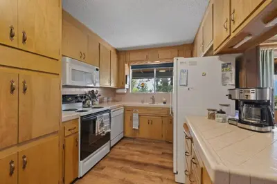 a kitchen with wooden cabinets and a white refrigerator at Mountain View House in Mi-Wuk Village
