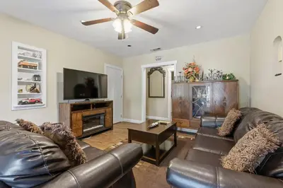 a living room with leather furniture and a flat screen tv at Beautiful house by the river and the villager in Fair Oaks