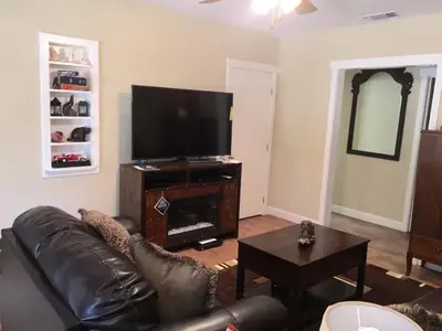 a living room with a couch and a flat screen tv at Beautiful house by the river and the villager in Fair Oaks