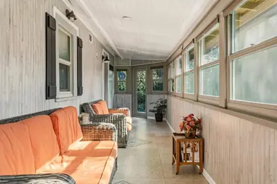 a screened in porch with couches and windows at Beautiful house by the river and the villager in Fair Oaks