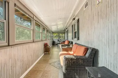 a screened in porch with two wicker chairs and windows at Beautiful house by the river and the villager in Fair Oaks