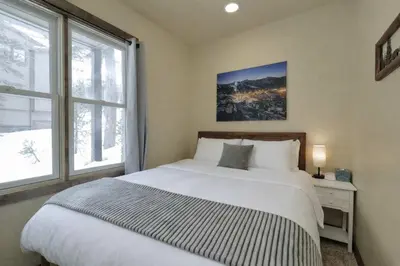 a bedroom with a large white bed and a window at Kirkwood Mountainside Cottage Deck Walk to Lifts in Kirkwood