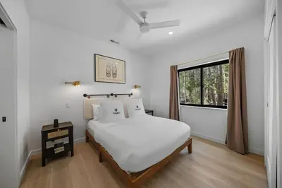 a white bedroom with a bed and a window at Donner Summit - Hot Tub, Fireplace & Mountain Views in Soda Springs