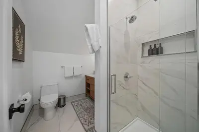 a white bathroom with a shower and a toilet at Donner Summit - Hot Tub, Fireplace & Mountain Views in Soda Springs