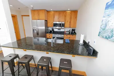 a kitchen with a counter with stools in it at The Meadows-Cozy Family Condo in Kirkwood Deck in Kirkwood
