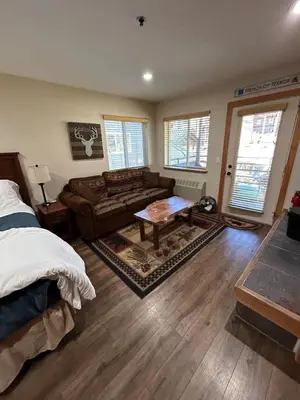 a bedroom with a bed and a couch and a table at The Meadows-Cozy Hotel Room Deck in Kirkwood