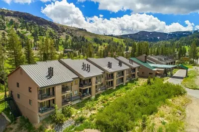 an aerial view of a building with mountains in the background at The Meadows-Cozy Hotel Room Deck in Kirkwood