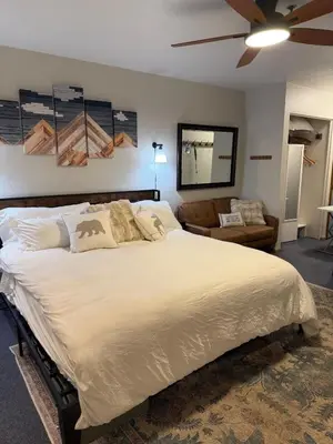 a bedroom with a large bed and a couch at The Meadows- Charmed Hotel Unit Steps to Ski Lifts in Kirkwood