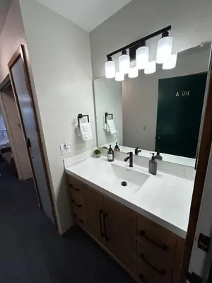 a bathroom with a sink and a large mirror at The Meadows- Charmed Hotel Unit Steps to Ski Lifts in Kirkwood