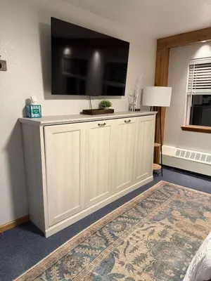 a living room with a large flat screen tv on a wall at The Meadows- Charming 1BD2BA Ski Condo in Kirkwood