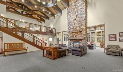 a large living room with a stone fireplace at The Meadows- Charming 1BD2BA Ski Condo in Kirkwood