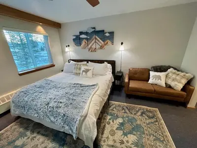 a bedroom with a large bed and a couch at The Meadows- Charming 1BD2BA Ski Condo in Kirkwood