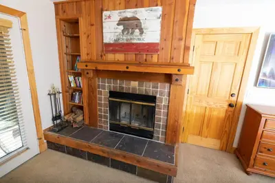 a living room with a brick fireplace with a mantle at The Meadows - 2 Bdrm Family Condo in Kirkwood in Kirkwood