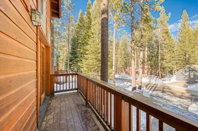 a wooden balcony with a view of a forest at Kindred Pines at Tahoe Donner by Tahoe Getaways - 3BR with Pool Table & HOA in Truckee