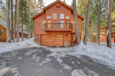 a log cabin in the woods in the snow at Kindred Pines at Tahoe Donner by Tahoe Getaways - 3BR with Pool Table & HOA in Truckee