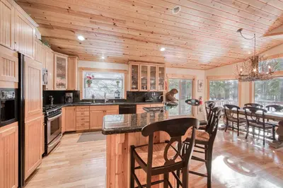a kitchen with wooden cabinets and a table with chairs at Kindred Pines at Tahoe Donner by Tahoe Getaways - 3BR with Pool Table & HOA in Truckee