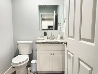 a white bathroom with a toilet and a sink at Cozy 3 Bedroom Walk to UC Davis Medical Near Midtown in Sacramento