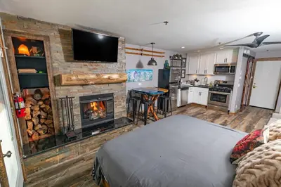 a bedroom with a fireplace and a bed in a room at Walk to the lifts hot tub covered parking luxury in Kirkwood