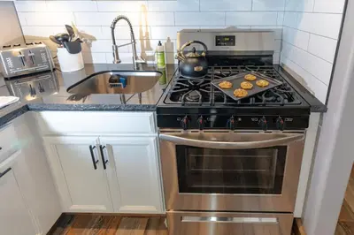 a kitchen with a stove top oven next to a sink at Walk to the lifts hot tub covered parking luxury in Kirkwood