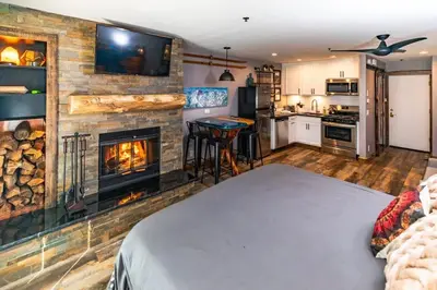 a bedroom with a fireplace and a bed in a room at Walk to the lifts hot tub covered parking luxury in Kirkwood