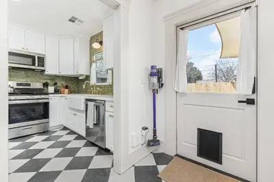 a kitchen with white cabinets and a checkered floor at 2 bed1 bath, historic beauty, walk downtown in Visalia