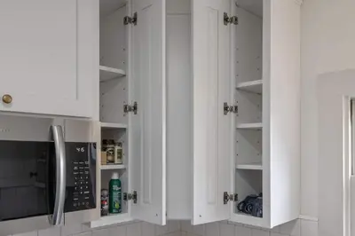 a white kitchen with white cabinets and a microwave at 2 bed, 2 bath, historic beauty, walk downtown in Visalia