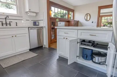 a kitchen with white cabinets and a tile floor at 2 bed, 2 bath, historic beauty, walk downtown in Visalia