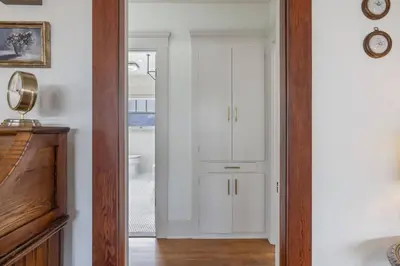 a hallway with white cabinets and a mirror at 2 bed, 2 bath, historic beauty, walk downtown in Visalia