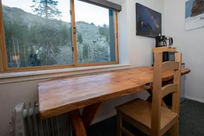 a wooden desk in a room with a window at Ski in Ski out King Bed Suite Hotel Room Near Village in Kirkwood